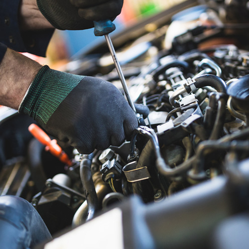 Mechanic tuning up a car engine during engine repair in Gaithersburg, MD