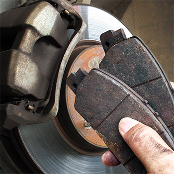 Hands holding brake repair tool during brake service in Gaithersburg