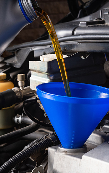 Oil poured into a blue car filter during oil changes