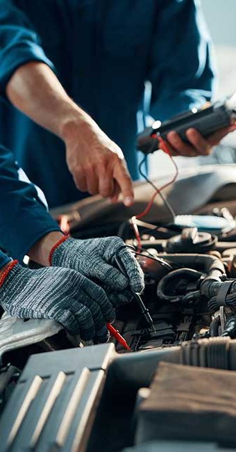 A pair of gloved mechanic's hands work on an engine during fleet service in Gaithersburg